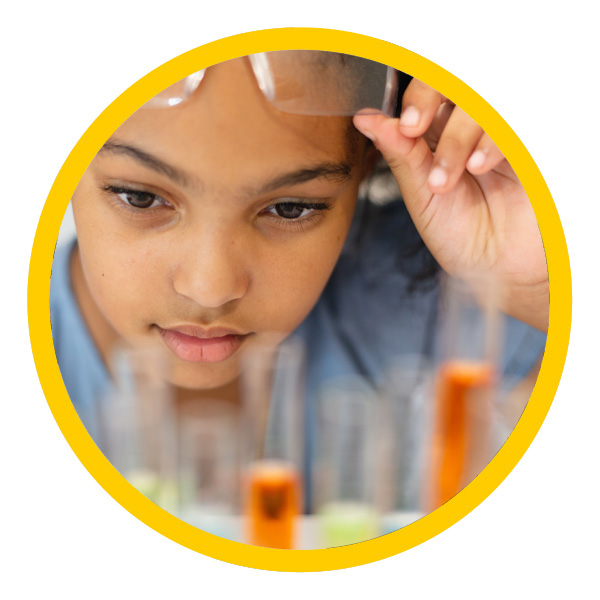 young girl looking at beakers